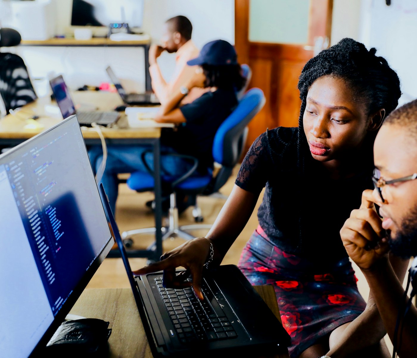 A team working together at a desk with laptops