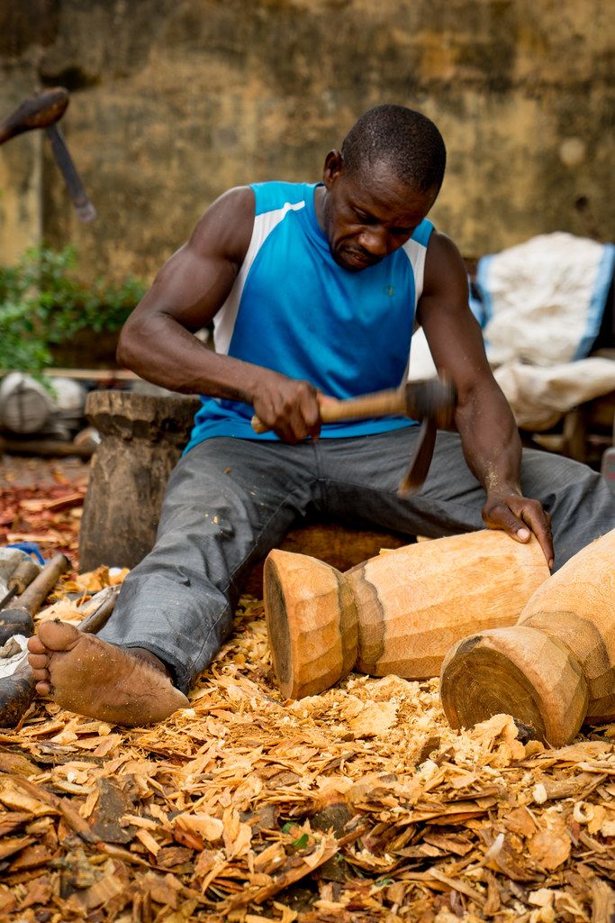Woodcarver shaping timber with a mallet and chisel